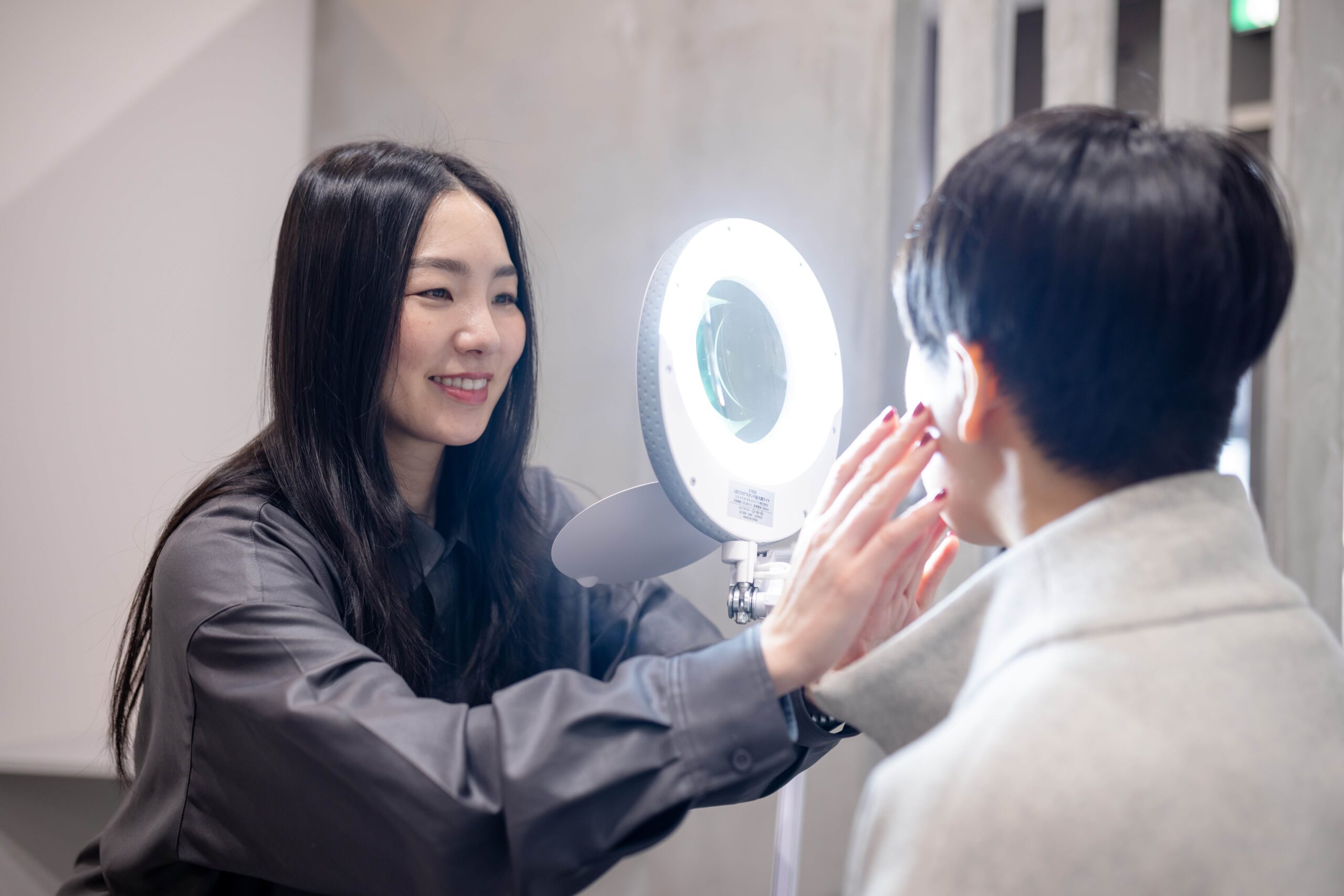 美肌ケアから美眉までトータルでサポートする美容サービス - 拡大鏡を使用した肌分析でお顔のトータルビューティーを提案